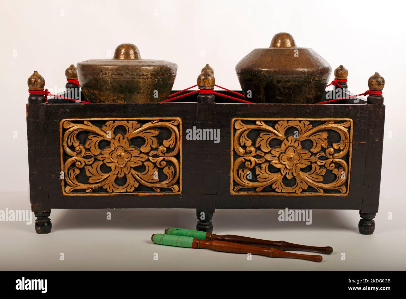 Bonang,  an Indonesian musical instrument used in the Javanese gamelan. Bronze gongs balanced on string with a decorative wooden frame. With beaters. Stock Photo