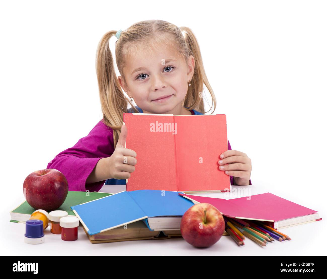 Little smart girl holding a book and reading it, on a white background