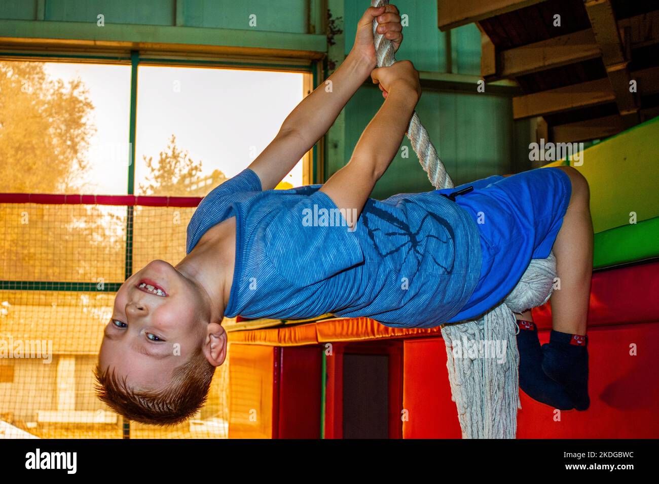 a little boy is hanging on a rope Stock Photo Alamy