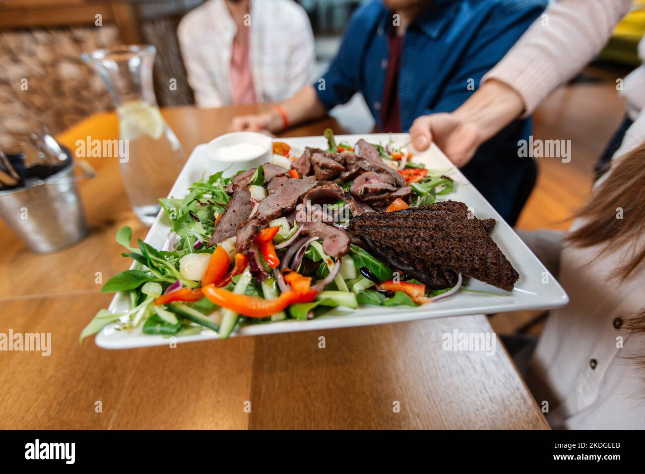 close up of hand with food on plate at restaurant Stock Photo