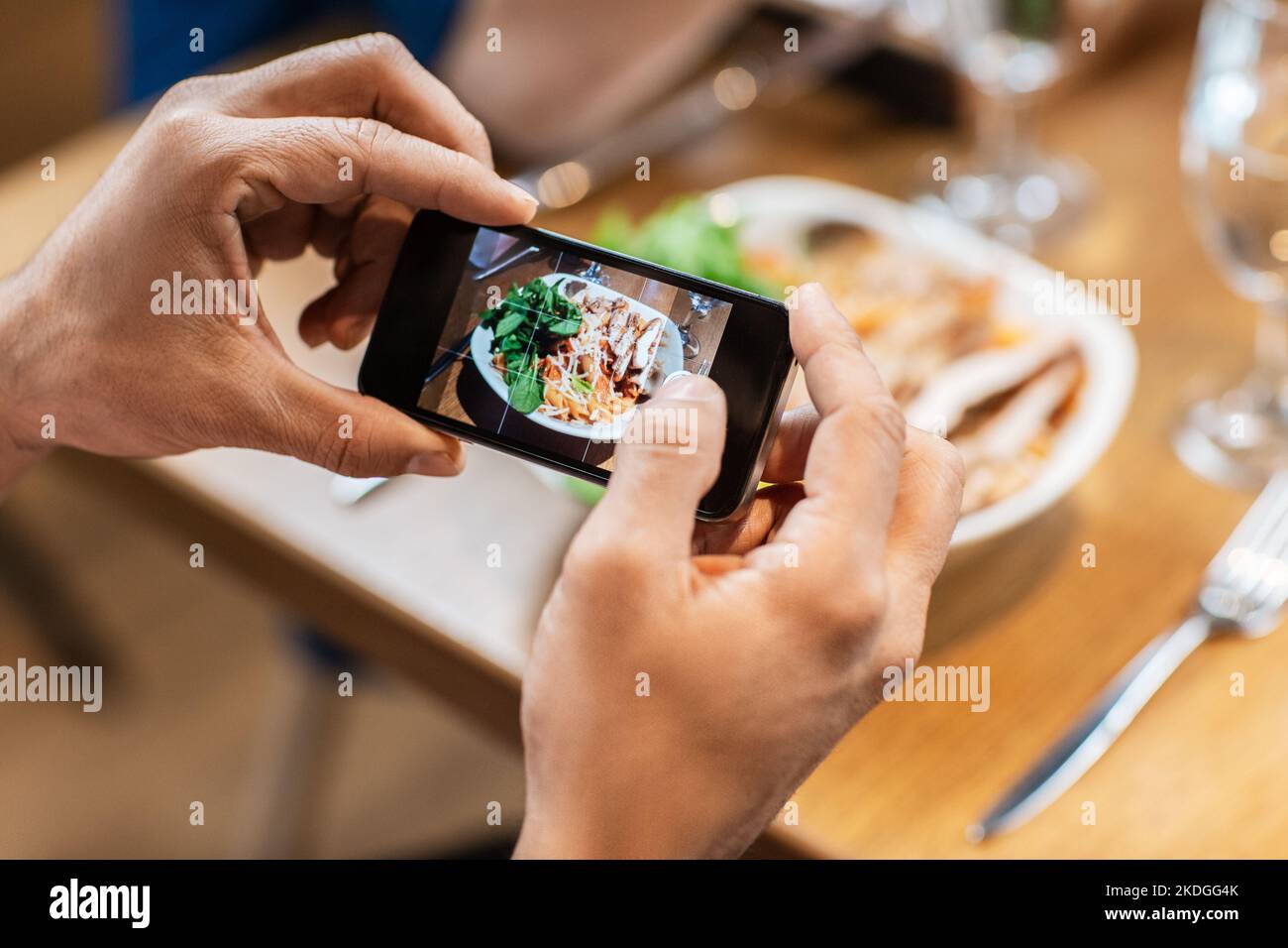 man with phone photographing food at restaurant Stock Photo