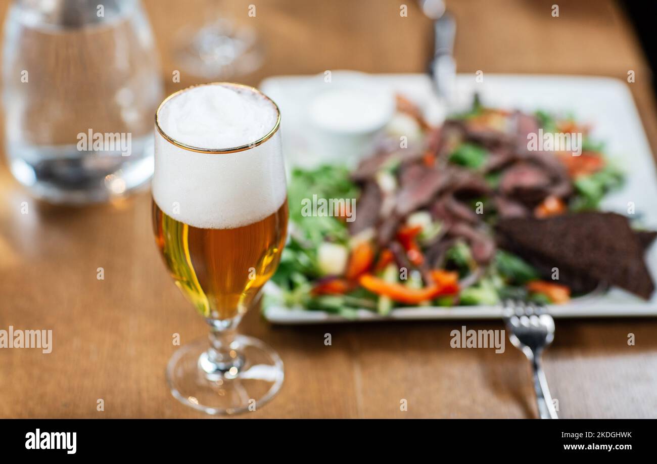 close up of beer glass and food at restaurant Stock Photo