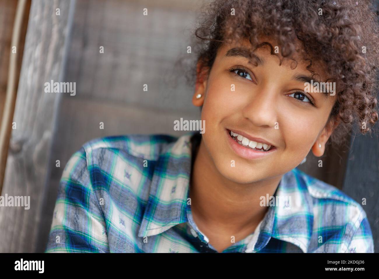 Portrait of happy African American teen girl looking at camera at home,  headshot of smiling black teenager posing indoors, beautiful mixed race  teenage female laughing making picture Stock Photo