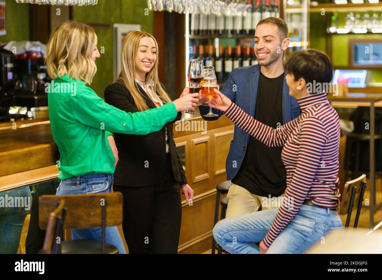 Cheerful men and women toasting at a bar counter Stock Photo