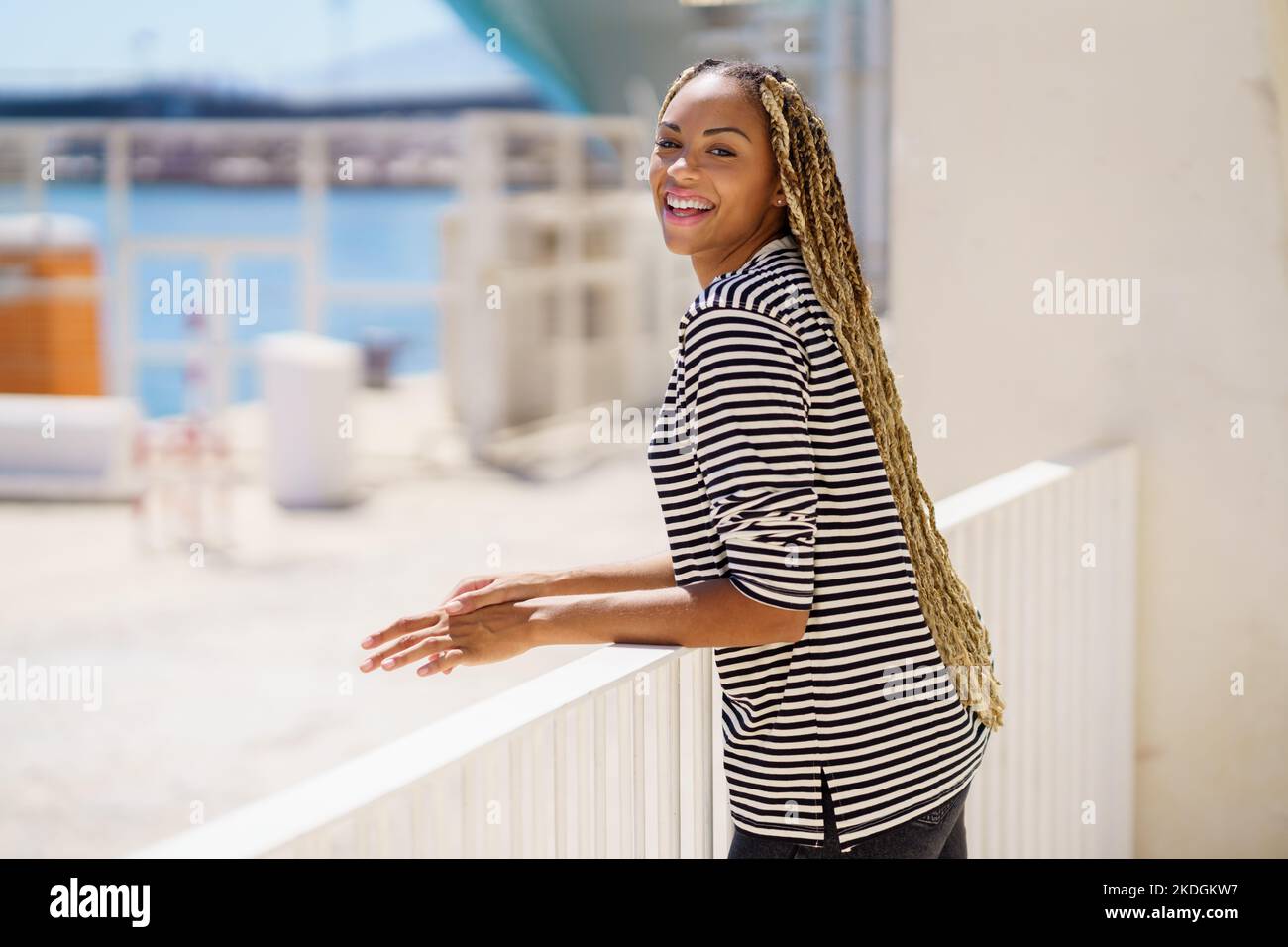 Young black woman enjoying the view of the seaport. Stock Photo