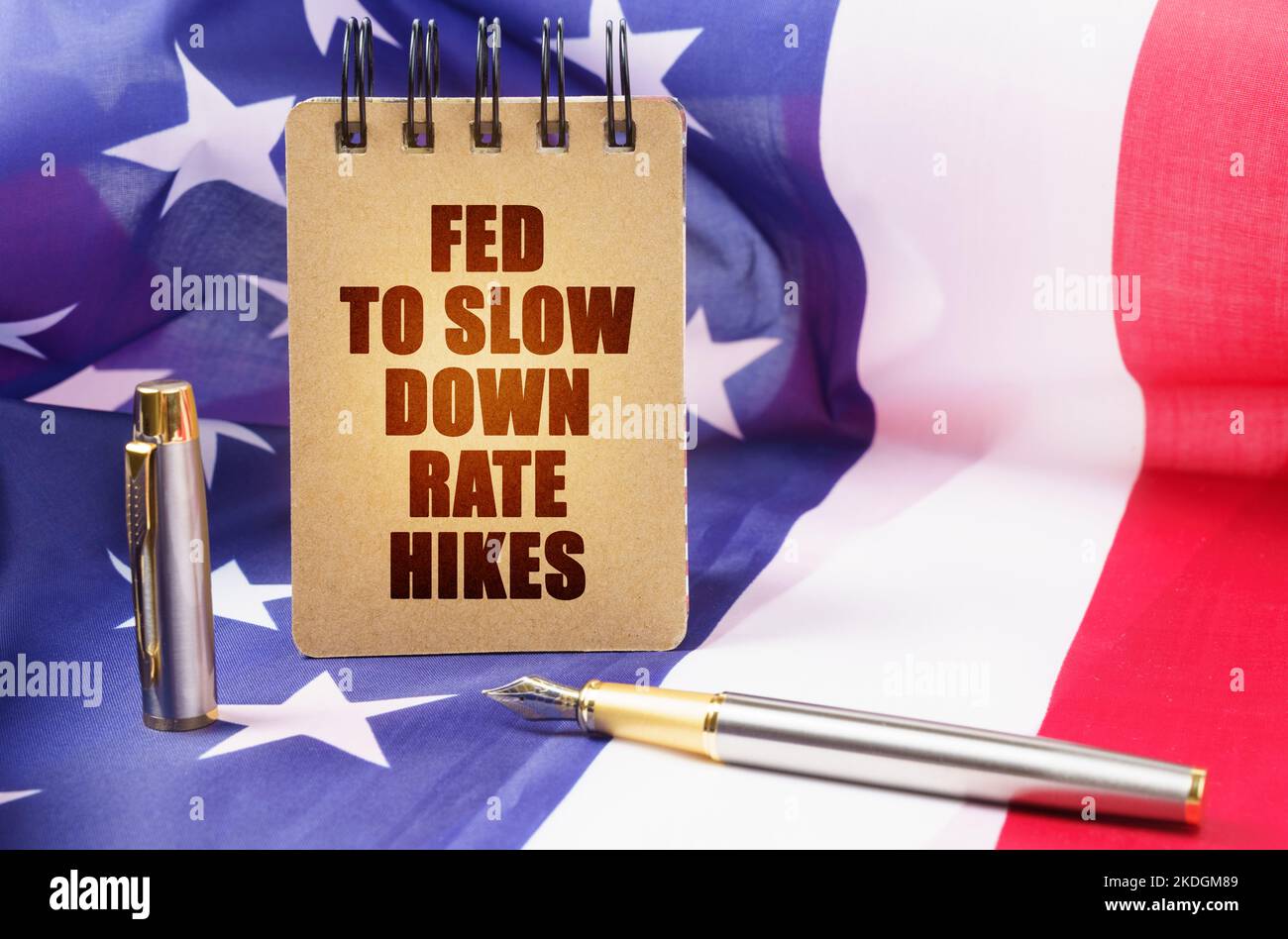 Business concept. Against the background of the American flag is a notepad with the inscription - Fed to slow down rate hikes Stock Photo