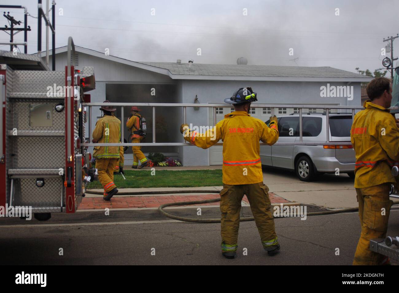San Diego Fire-Rescue fire fighter pulls a ladder while working a structure fire in the Kearny Mesa section of San Diego Stock Photo