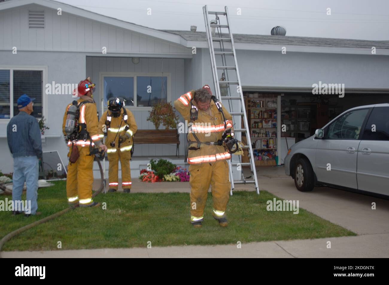 San Diego Fire-Rescue fire fighters (and a spectator) outside of a working structure fire in the Kearny Mesa section of San Diego Stock Photo