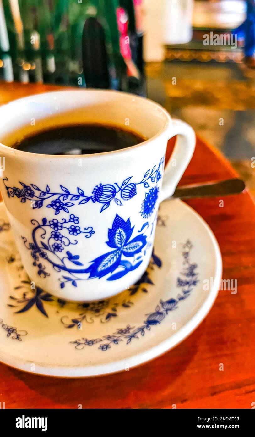 Blue and white cup pot with black coffee americano on wooden table in