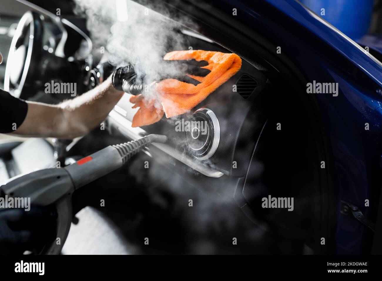 Steam cleaning of car air system. Worker in auto cleaning service clean car inside. Car interior