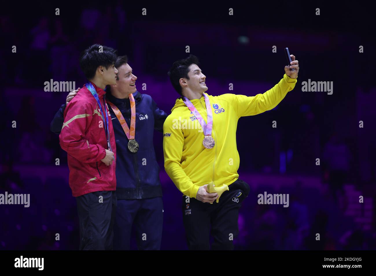 November 6, 2022: Brody Malone (USA) wins gold on the horizontal bar at the 2022 Artistic Gymnastics World Championships. Daiki Hashimoto (JPN) wins silver and Arthur Mariano (BRA) takes bronze. The medalists pause for a selfie on the podium. The event is at M&S Bank Arena in Liverpool, England. Melissa J. Perenson/CSM Stock Photo