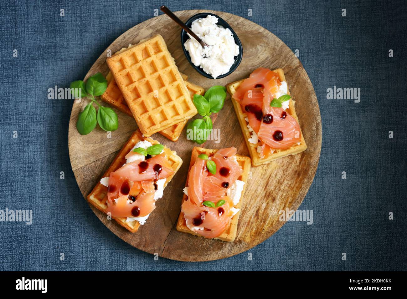 Salmon sandwich on Viennese waffles with ricotta cheese. Delicious waffles with salmon and cream cheese. Stock Photo