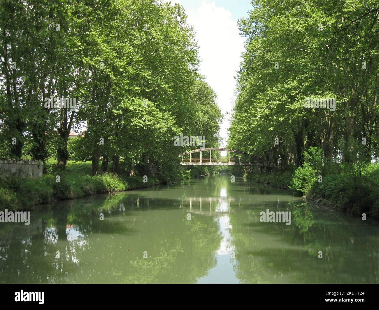 Southern France, side canal of the Garonne river, ( called  Canal lateral a la Garonne ) view of straight canal section with bridges and trees Stock Photo