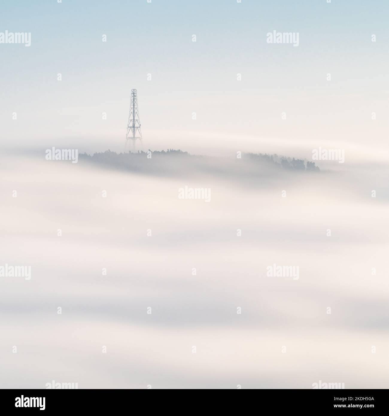 The radio mast atop Norwood Edge is visible above a soft white blanket of mist during an autumn temperature inversion filling the Washburn Valley. Stock Photo