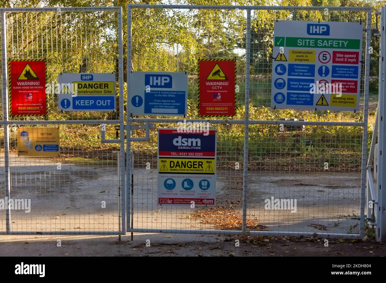 Construction site gate with various warning signs incl. 'DSM demolition' Stock Photo
