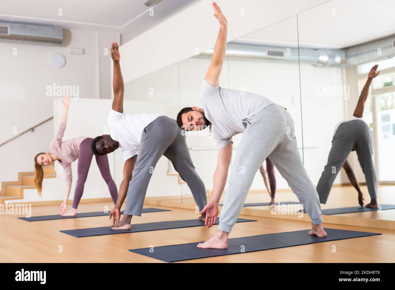 Men and woman doing windmill exercise in gym Stock Photo Alamy