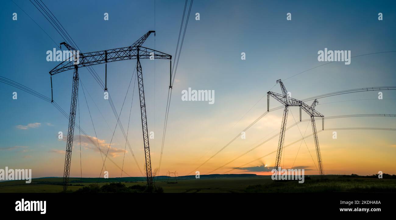 High voltage towers with electric power lines at sunset Stock Photo - Alamy