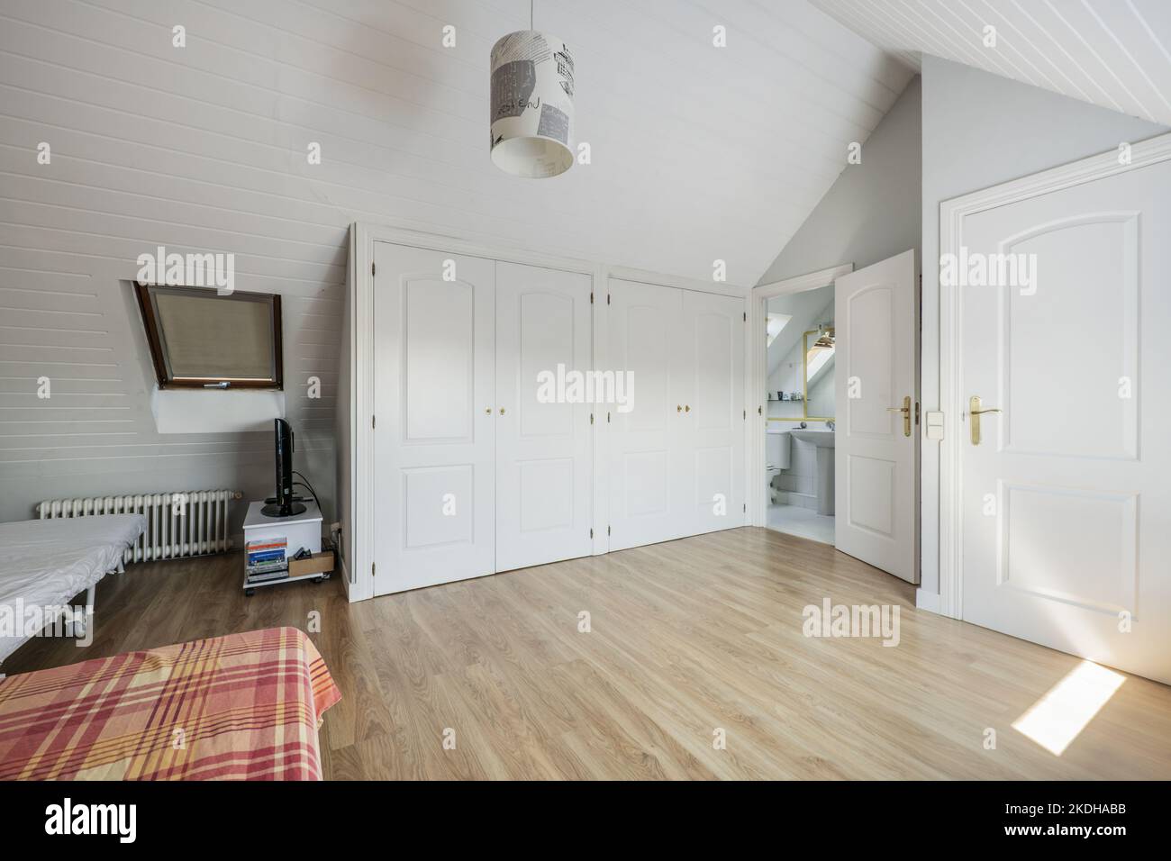 Double bedroom with en-suite bathroom and dressing room on the attic floor of a single-family home Stock Photo