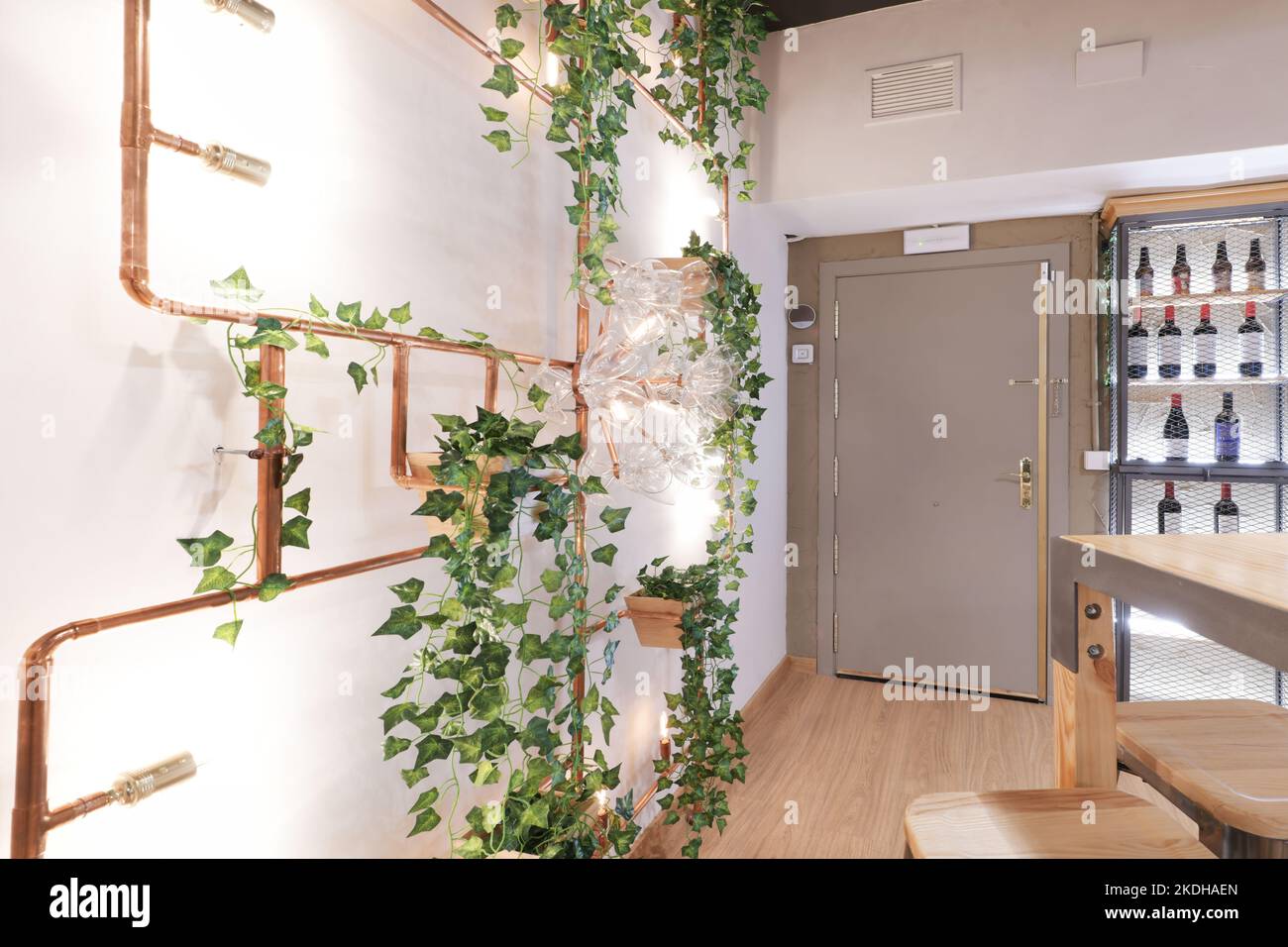 Room with high dining tables and decoration with vines in the