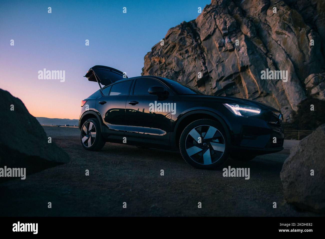 A Volvo C40 - an electric car - parks next to the beach. Stock Photo