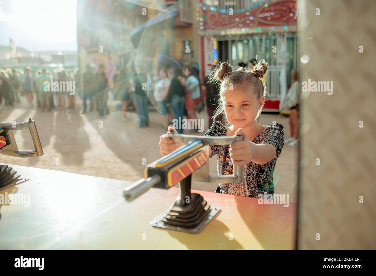 Young girl playing a carnival game on sunny day Stock Photo