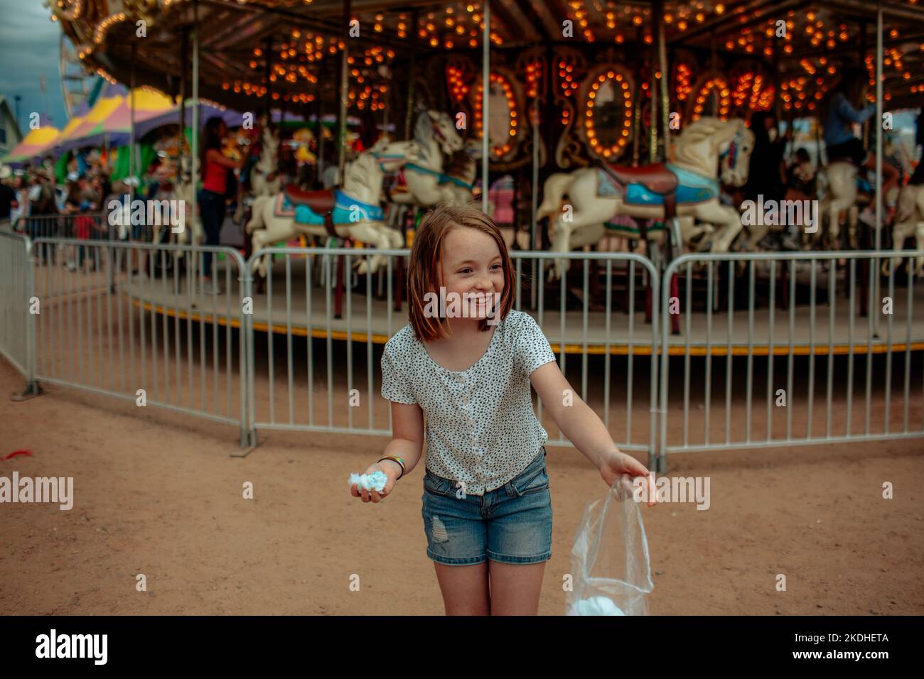 Young girl smiling and laughing in front of a carnival ride Stock Photo ...