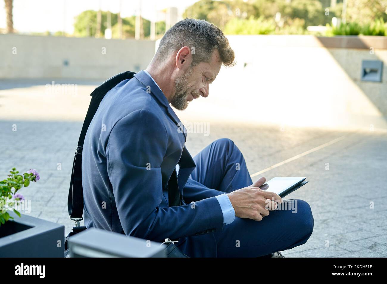 Smiling businessman with skateboard using tablet on platform Stock Photo