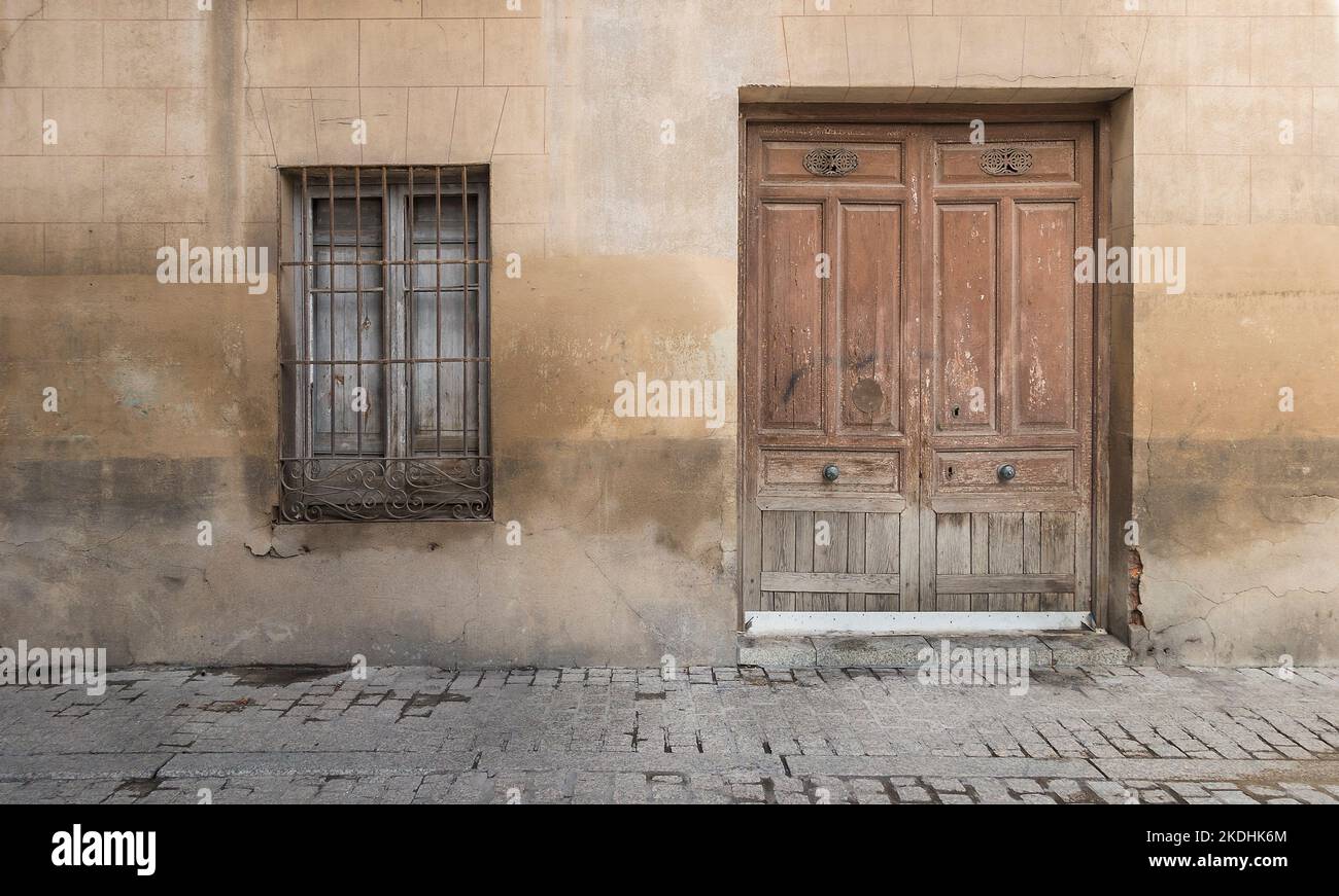 Old wooden door and old wooden window with bars Stock Photo