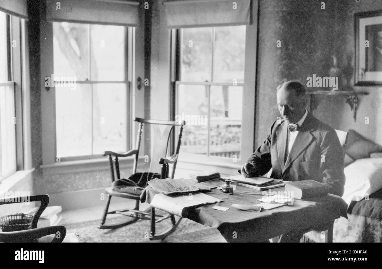 A 1913 portrait of President Calvin Coolidge seated at his desk in his home in Rutland, VT Stock Photo