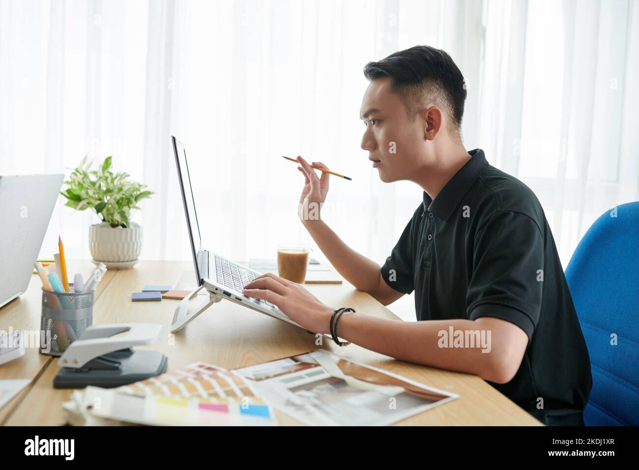 Young serious interior designer creating project for client Stock Photo ...