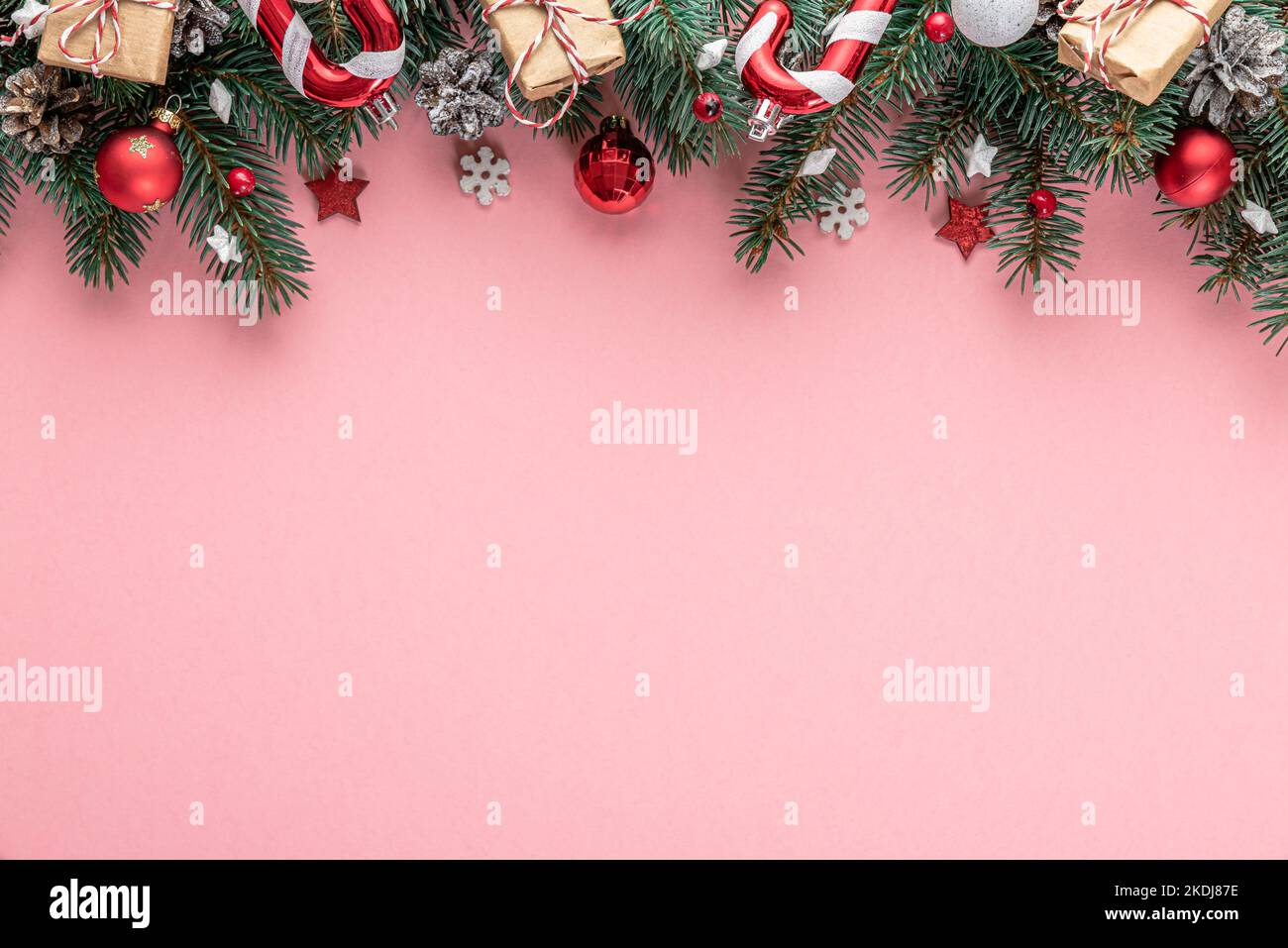 Christmas background with fir tree, holiday decorations, gift boxes on pink background. Flat lay. Top view with copy space. Festive background Stock Photo