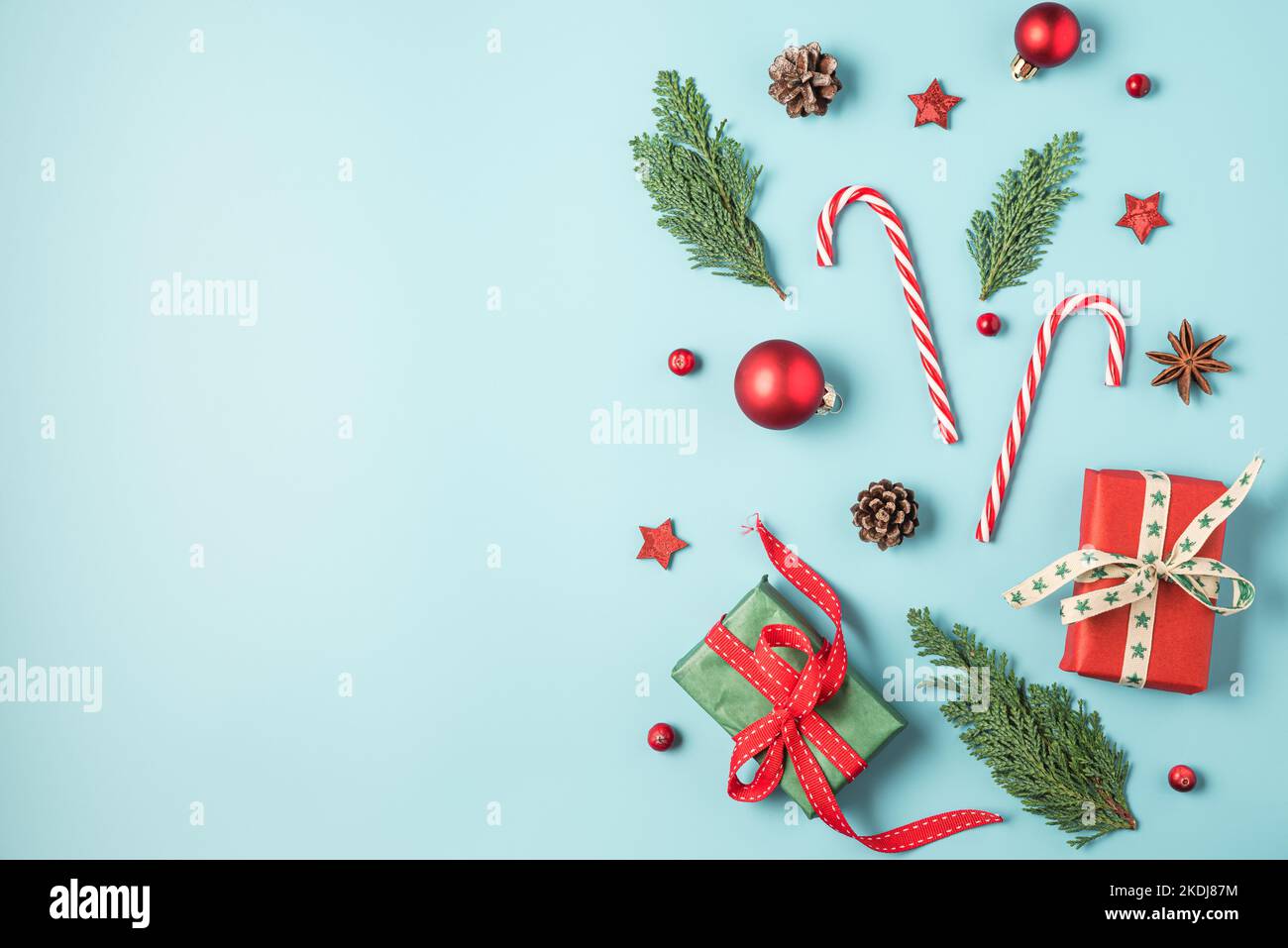 Christmas background with fir tree, holiday decorations, gift boxes on blue background. Flat lay. Top view with copy space. Festive background Stock Photo