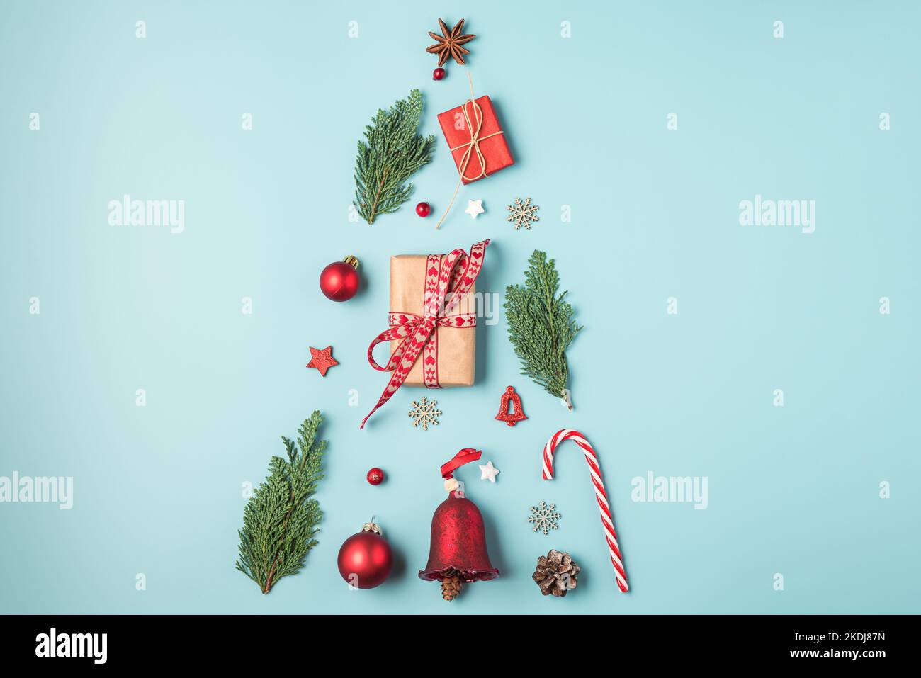 Christmas fir tree made of holiday decorations, gift boxes, fir branches on blue background. Flat lay. Top view. Festive background Stock Photo