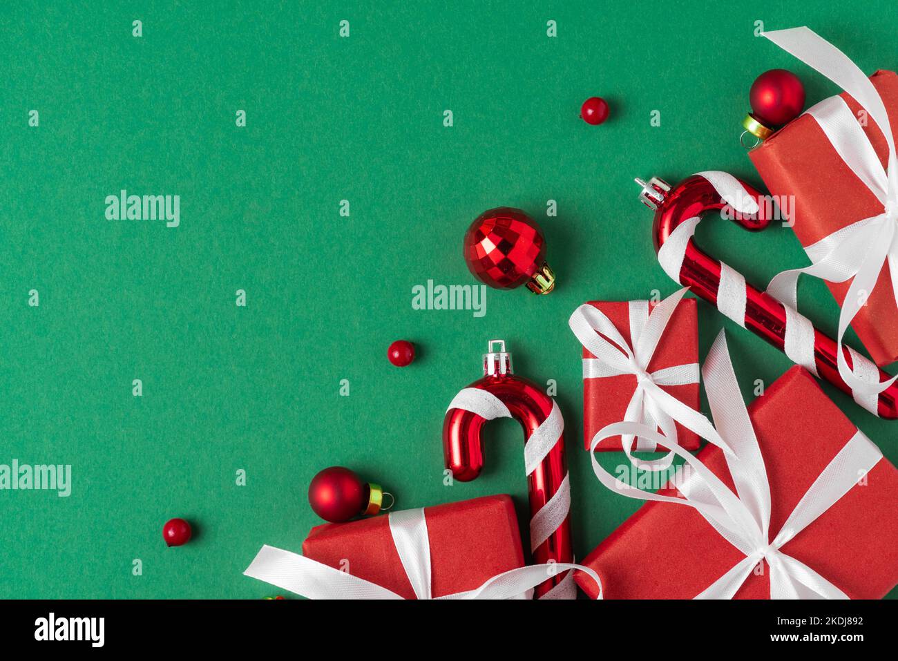 Christmas red gift boxes on green background. Christmas composition with decorations and holiday presents. Flat lay. Top view. Festive winter backgrou Stock Photo