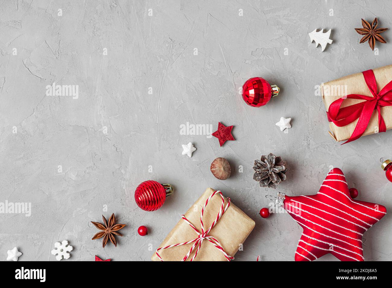 Christmas or Happy New Year background. Gift boxes, red holiday decorations and Christmas star on gray background. Flat lay. Top view with copy space Stock Photo