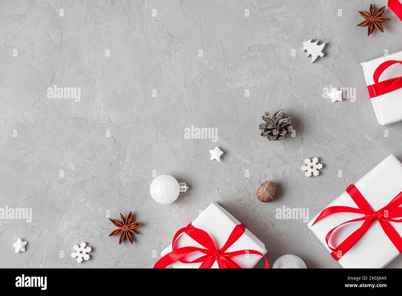 Christmas or Happy New Year composition. White gift boxes with holiday decorations on gray background. Flat lay. Top view with copy space Stock Photo