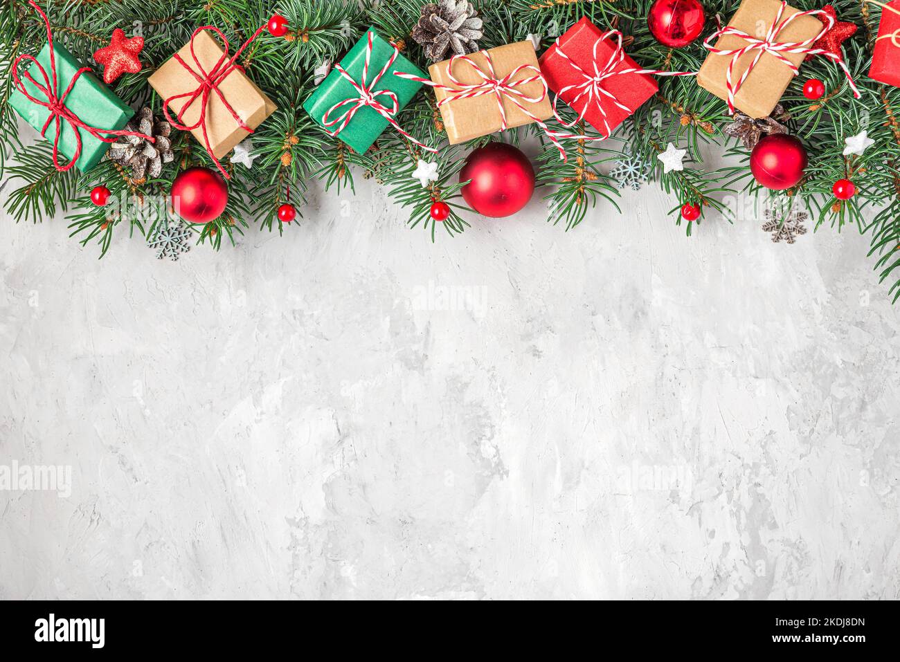 Christmas background with fir tree, holiday decorations, gift boxes on gray concrete background. Flat lay. Top view with copy space. Festive backgroun Stock Photo