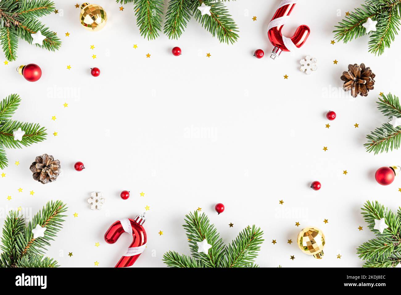 Christmas composition. Frame made of fir tree branches, holiday decorations on white background. Flat lay. Top view with copy space Stock Photo