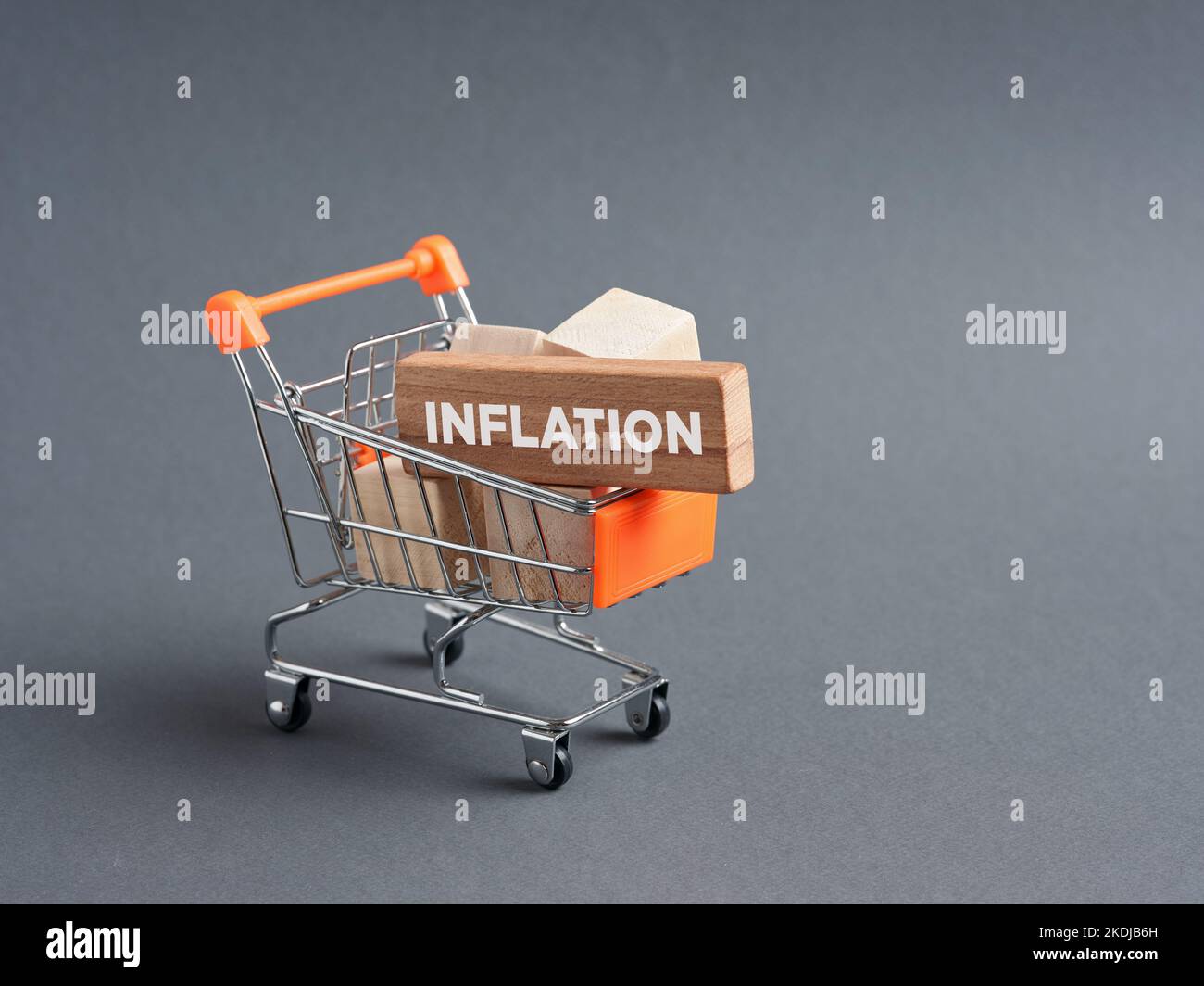 Shopping cart trolley with wooden blocks with the word inflation. Consumer price rise, loosing purchasing power. Stock Photo