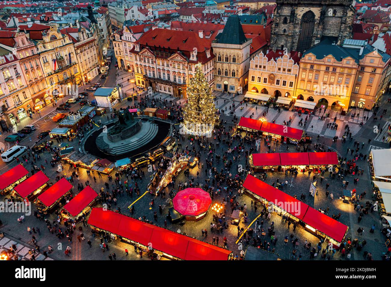 View from above of illuminated Christmas tree, market kiosks with red roofs and people on Old Town Square in Prague, Czechia. Stock Photo