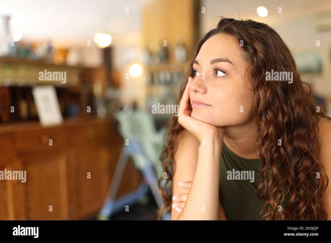 Distracted and pensive woman looking away in a restaurant Stock Photo