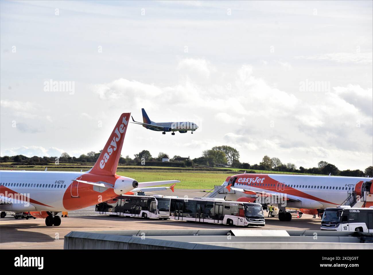 Bristol Commercial Airport, Boeing 737-800 easyJet airliners are parked awaiting take off while a 737-800 Jet2.com lands . Stock Photo
