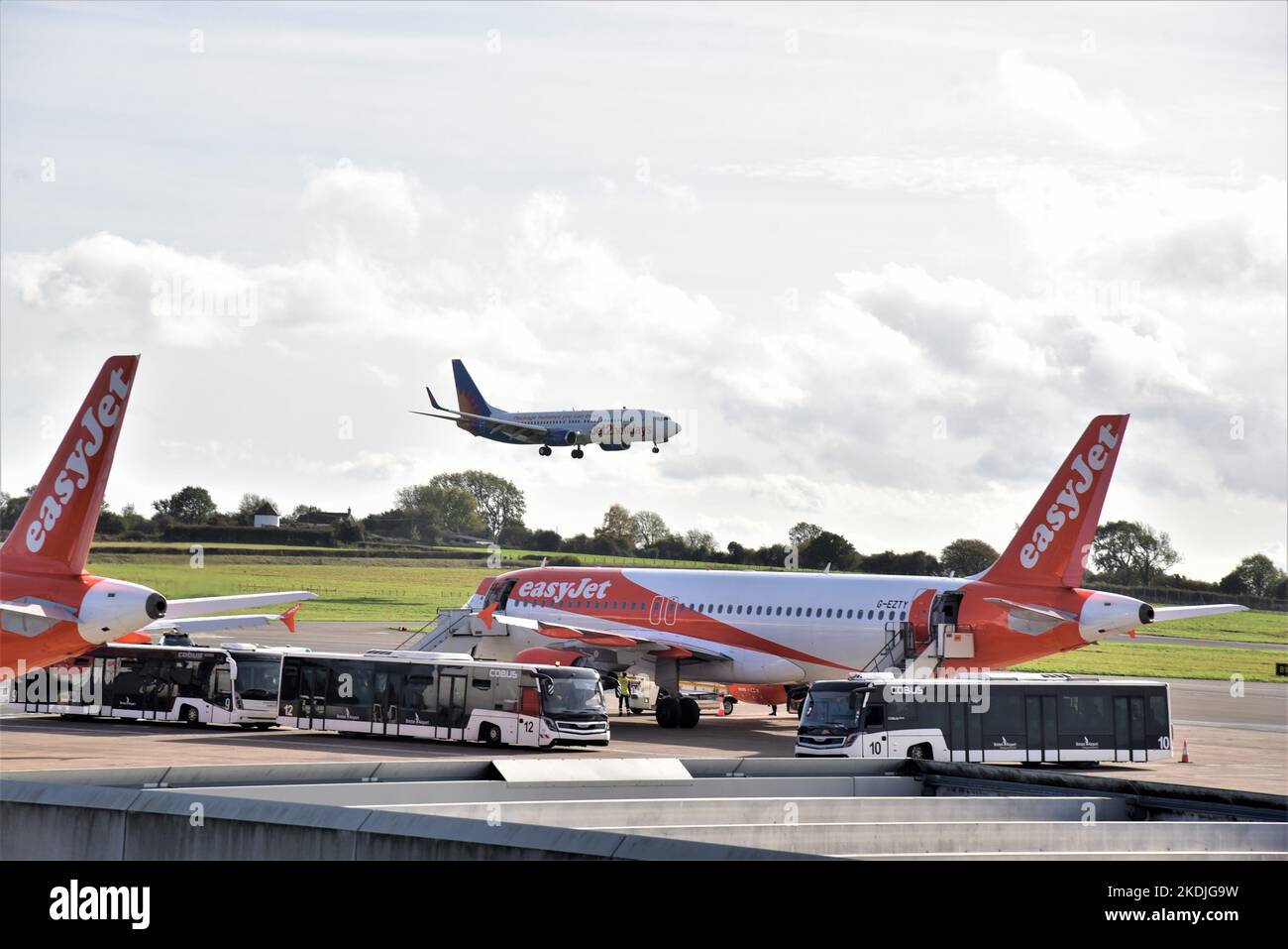 Bristol Commercial Airport, Boeing 737-800 easyJet airliners are parked awaiting take off while a 737-800 Jet2.com lands . Stock Photo