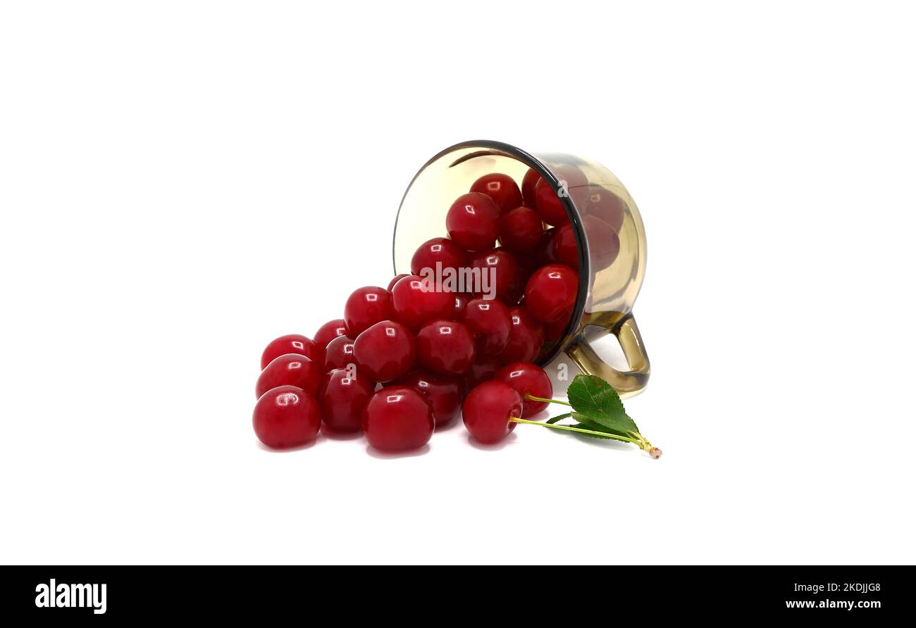 Ripe cherry in a transparent glass on a light background. Natural ...