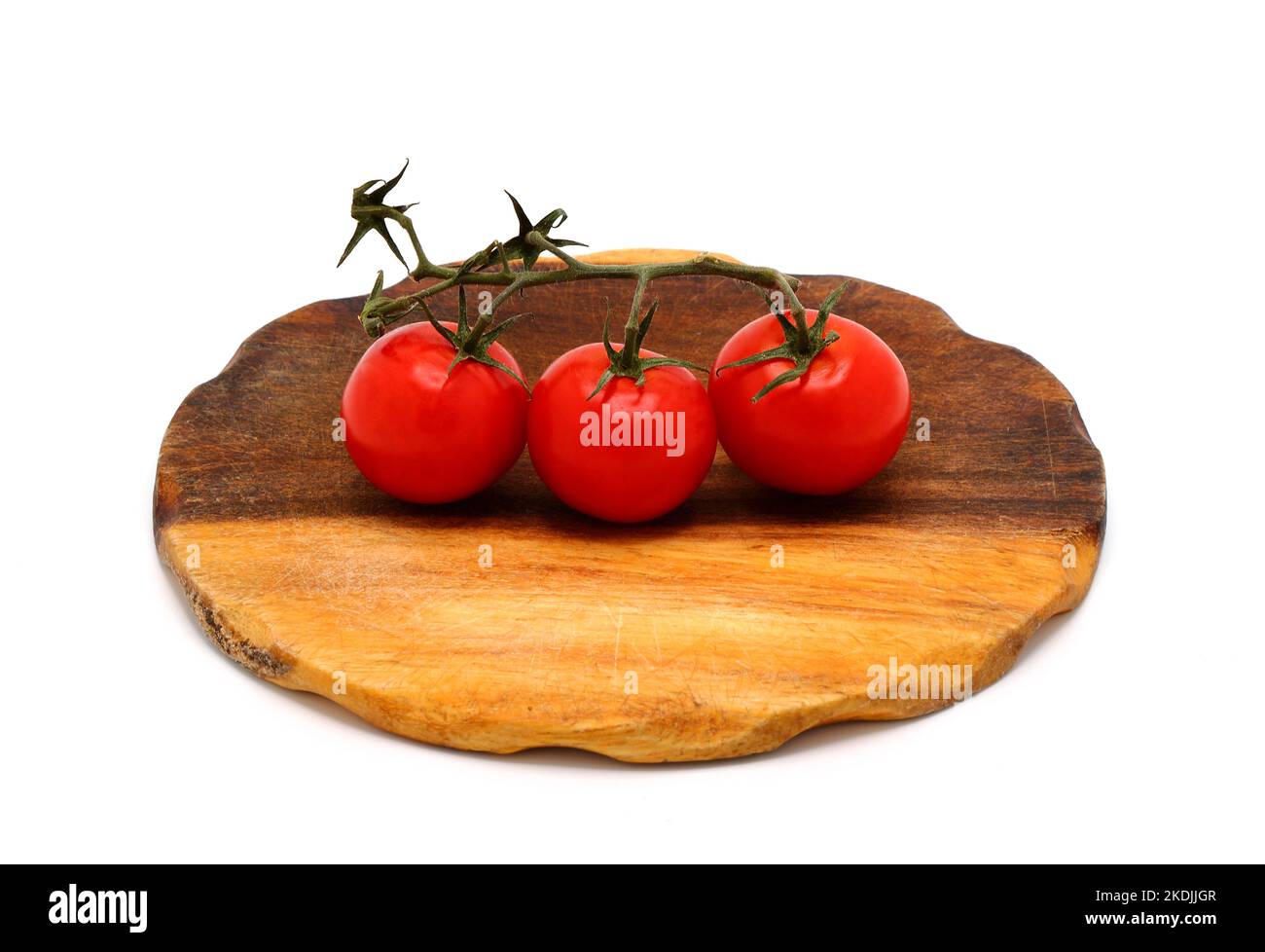 Three red ripe tomatoes on a cutting board on a light background Stock ...