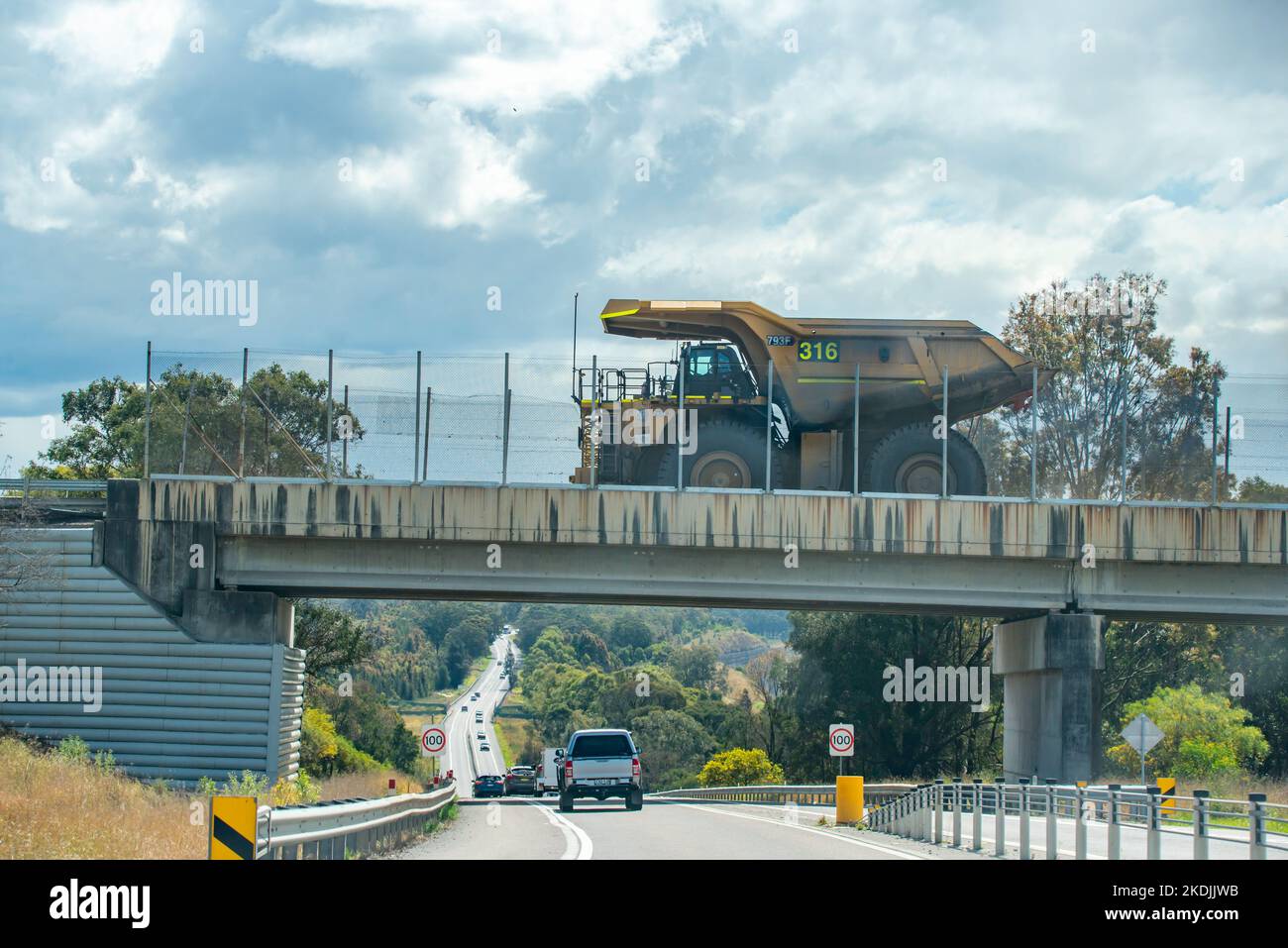 A large coal haul truck crosses the New England Highway on a dedicated mine road at Rix Creek Coal Mine, west of Singleton, New South Wales, Australia Stock Photo