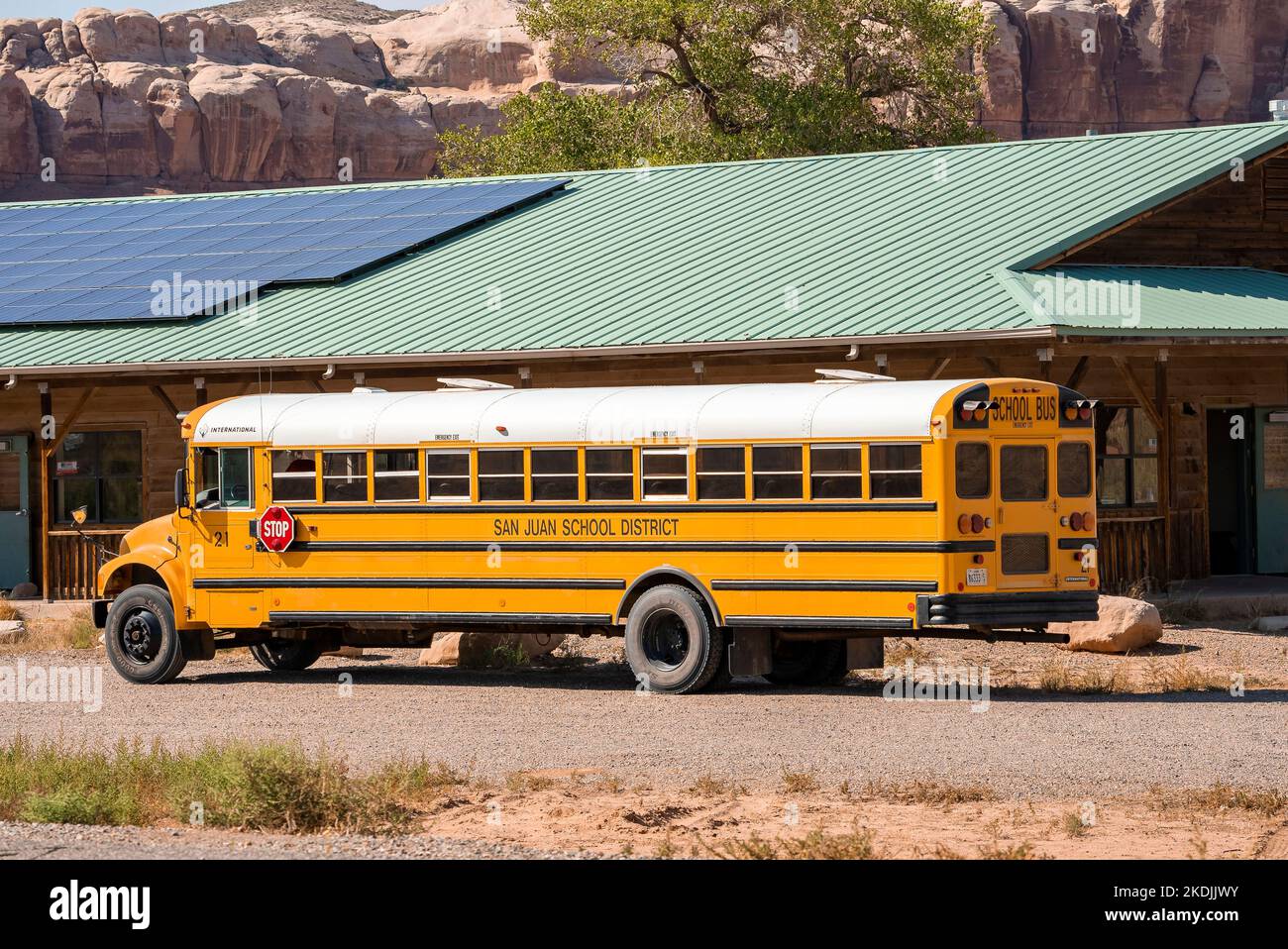 School Bus Parked By Building With Solar Panels On Roof Stock Photo Alamy