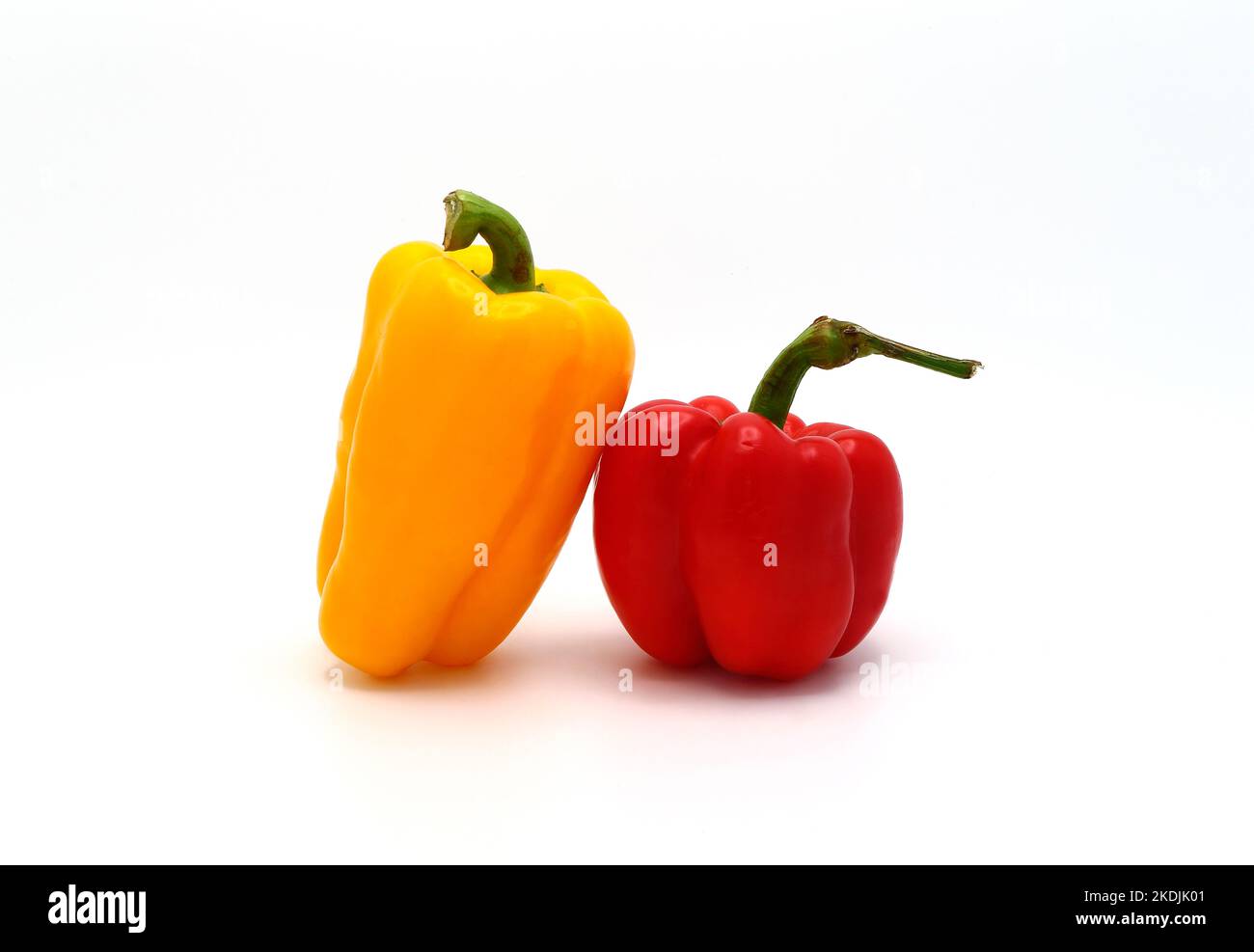 Two sweet peppers of yellow and red color on a light background