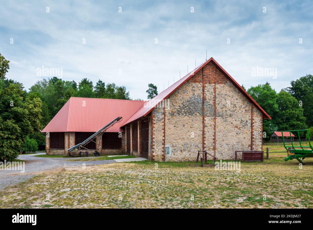 A beautiful large barn at the horse farm in Florianka. Red corrugated metal sheet on the roof of the barn Stock Photo