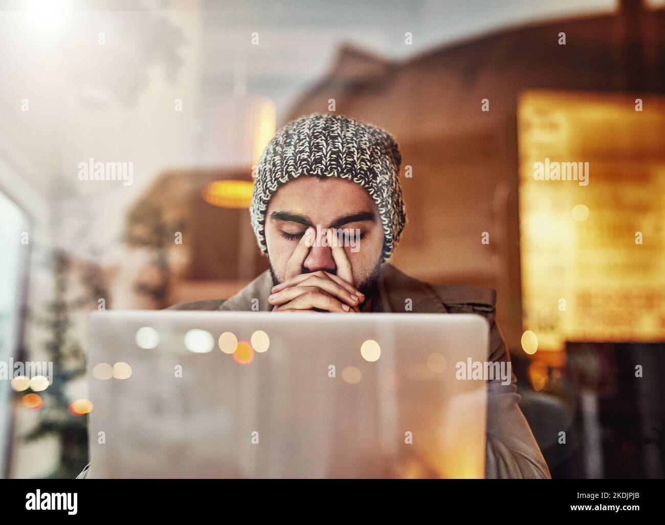 Why didnt I backup my files...a young man looking stressed while using a laptop in a cafe. Stock Photo
